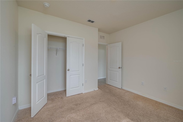 unfurnished bedroom with baseboards, visible vents, and light colored carpet