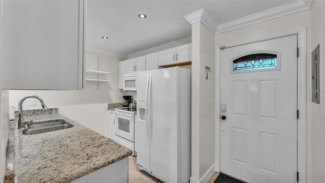 kitchen with open shelves, white cabinetry, a sink, light stone countertops, and white appliances