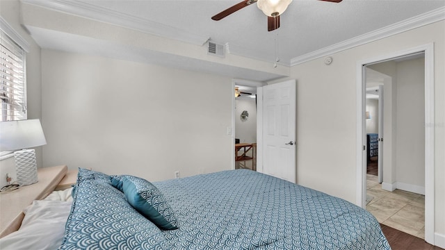 tiled bedroom with visible vents, ornamental molding, ceiling fan, a textured ceiling, and baseboards