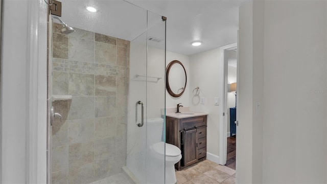 bathroom featuring toilet, vanity, baseboards, a shower stall, and tile patterned floors