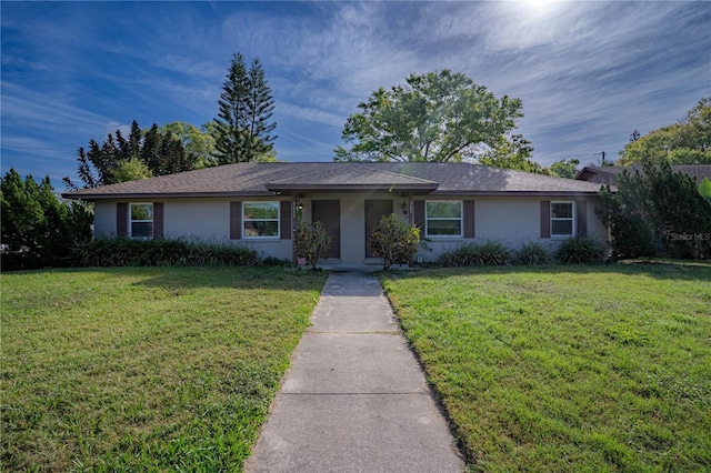 single story home featuring a front yard and stucco siding