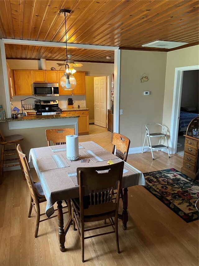 dining area with wooden ceiling, light wood-style flooring, and baseboards