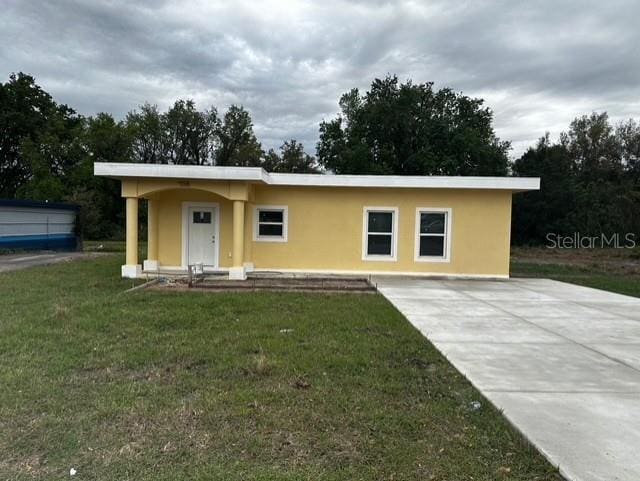 view of front of house featuring a front lawn and stucco siding