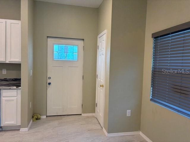 foyer featuring baseboards