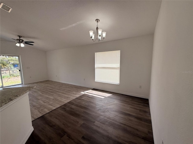 spare room with dark wood-style floors, visible vents, baseboards, and ceiling fan with notable chandelier