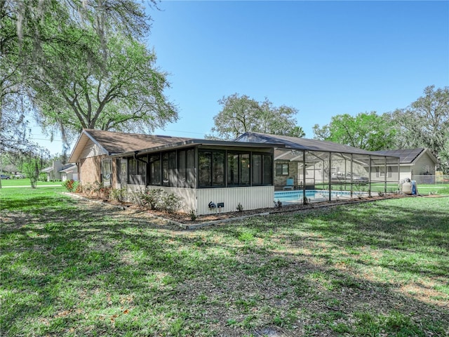 view of side of property with a lawn, a lanai, and an outdoor pool