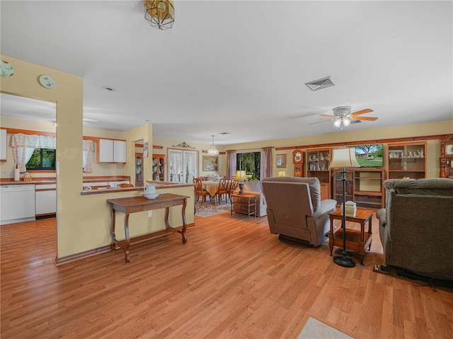 living area with plenty of natural light, light wood-style flooring, visible vents, and a ceiling fan