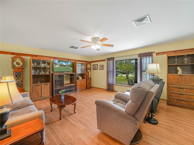 living room featuring ceiling fan, visible vents, and wood finished floors