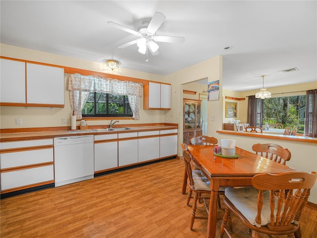 kitchen featuring visible vents, white dishwasher, a sink, and white cabinetry