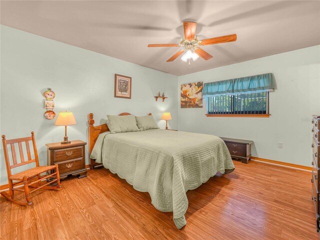 bedroom with light wood-type flooring, a ceiling fan, and baseboards