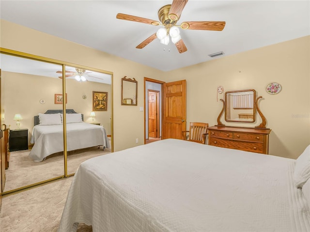 bedroom featuring ceiling fan, a closet, visible vents, and light colored carpet