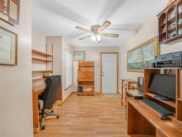 office area featuring light wood finished floors, a ceiling fan, and baseboards