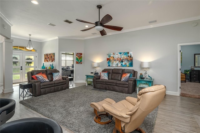 living area featuring baseboards, a ceiling fan, wood finished floors, and crown molding