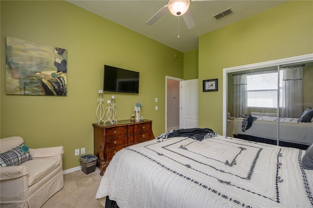 bedroom with visible vents, baseboards, light colored carpet, a closet, and a ceiling fan