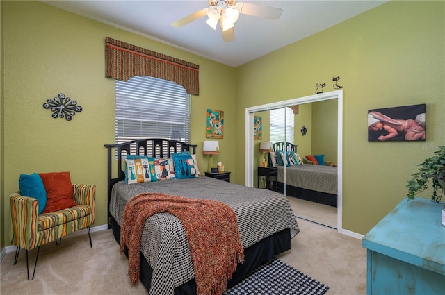 carpeted bedroom with a closet, baseboards, and a ceiling fan