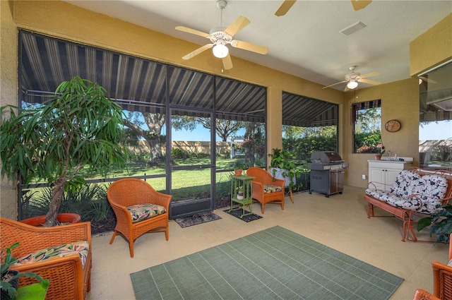 sunroom with ceiling fan, visible vents, a wealth of natural light, and a sink