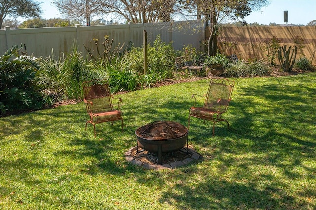 view of yard with a fire pit and a fenced backyard