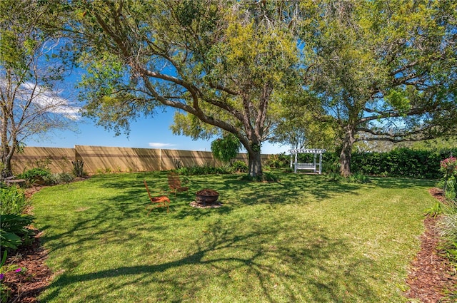 view of yard featuring a fenced backyard and an outdoor fire pit