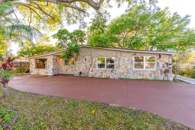 view of front facade with stone siding and fence