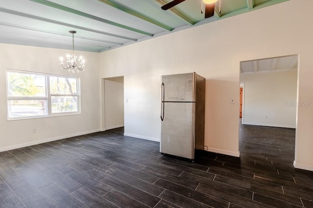 spare room with dark wood finished floors, baseboards, and ceiling fan with notable chandelier