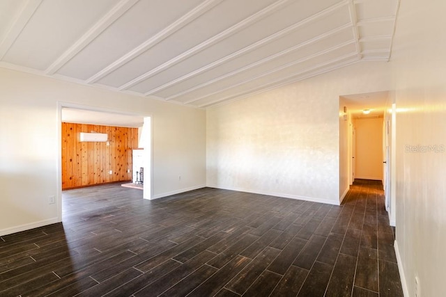 unfurnished room with lofted ceiling with beams, baseboards, and dark wood-type flooring