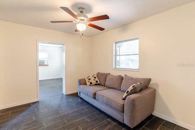 living room featuring dark wood-type flooring, a ceiling fan, and baseboards