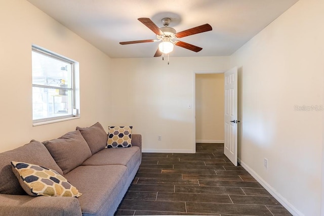 living area featuring a ceiling fan, wood tiled floor, and baseboards