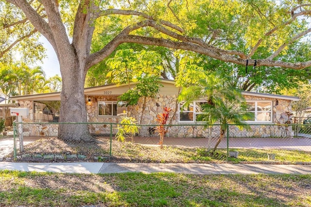 view of front of home featuring a fenced front yard and stone siding