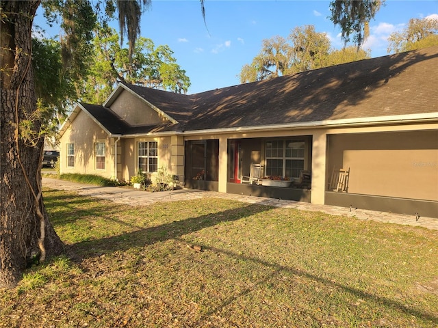 ranch-style home with stucco siding and a front lawn