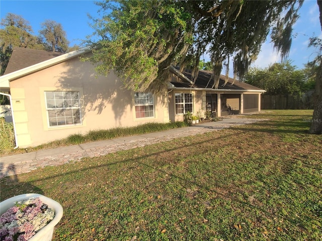 exterior space with a front yard, an attached garage, and stucco siding