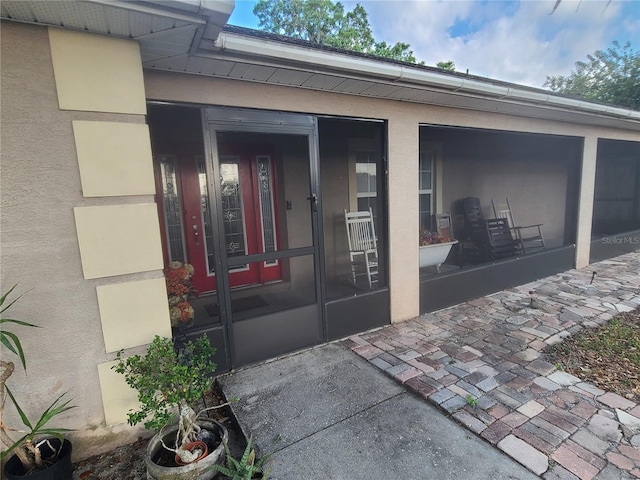 entrance to property featuring stucco siding