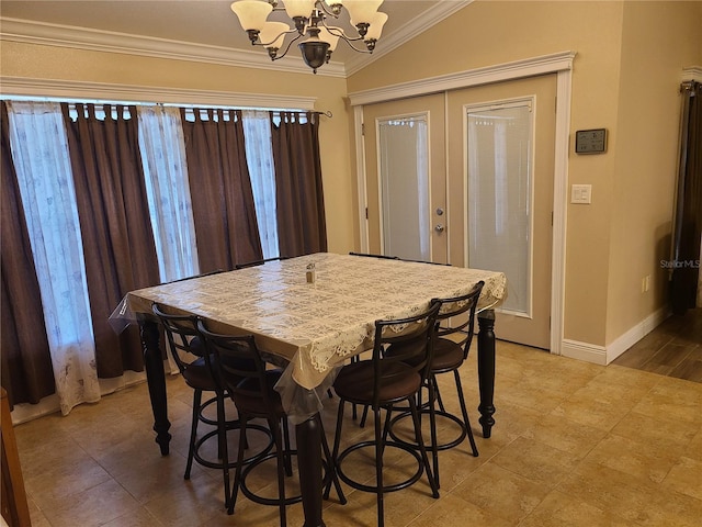 dining area with a notable chandelier, baseboards, crown molding, and lofted ceiling