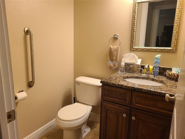 half bathroom with baseboards, toilet, vanity, and tile patterned flooring