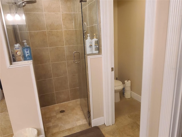 full bath featuring tile patterned flooring, a shower stall, toilet, and baseboards