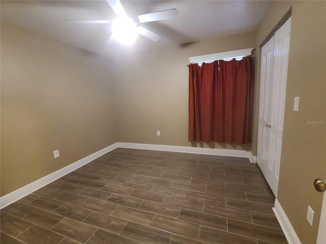 empty room with baseboards, ceiling fan, and wood tiled floor