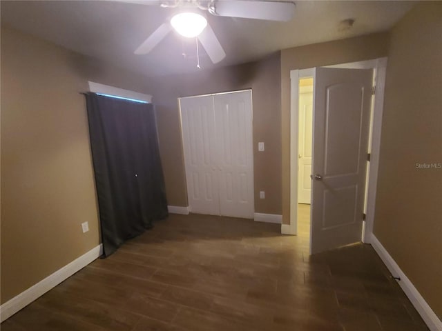 unfurnished bedroom with a ceiling fan, wood finished floors, baseboards, and a closet