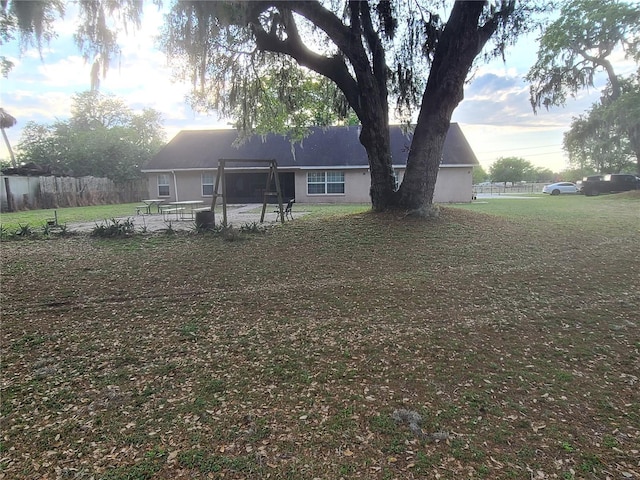 rear view of property with stucco siding and a lawn