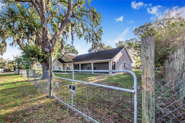view of front facade featuring a gate, fence, and a front lawn