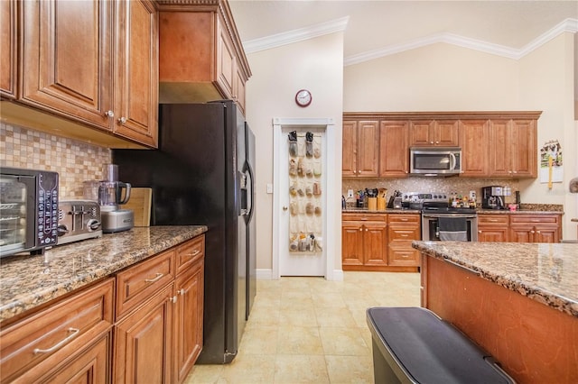 kitchen with stone counters, brown cabinetry, crown molding, and appliances with stainless steel finishes
