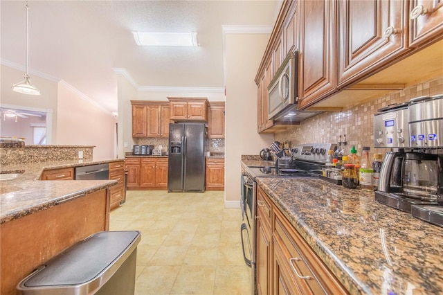 kitchen featuring ornamental molding, brown cabinets, appliances with stainless steel finishes, stone counters, and decorative light fixtures
