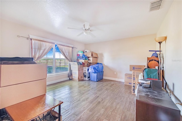 interior space featuring baseboards, ceiling fan, visible vents, and wood finished floors