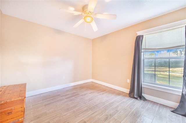 unfurnished room with baseboards, ceiling fan, and light wood-type flooring