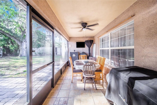 sunroom with tile patterned flooring and ceiling fan
