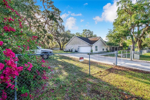 view of home's exterior featuring a gate, fence, an attached garage, concrete driveway, and a yard