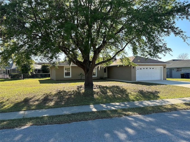 ranch-style house with driveway, a garage, fence, a front yard, and stucco siding