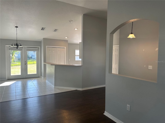 kitchen with baseboards, wood finished floors, visible vents, and a healthy amount of sunlight