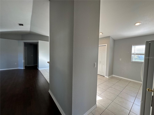 hall featuring light tile patterned floors, recessed lighting, visible vents, and baseboards