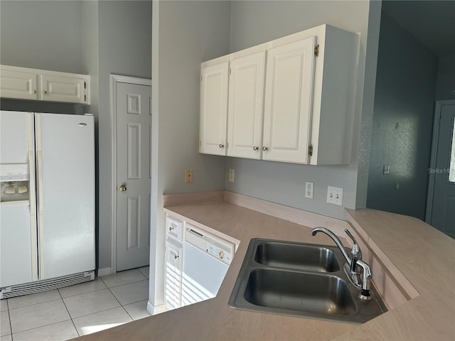 kitchen featuring white appliances, light tile patterned floors, light countertops, white cabinetry, and a sink