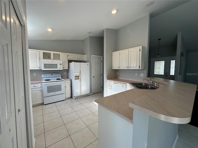 kitchen featuring white appliances, arched walkways, a peninsula, a sink, and light tile patterned flooring