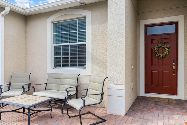 doorway to property featuring stucco siding